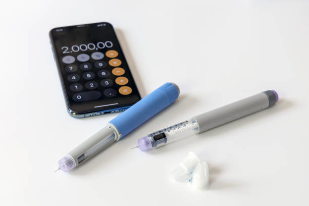 Lab setup showing 2 Tirzepatide syringes, and a calculator for dosing